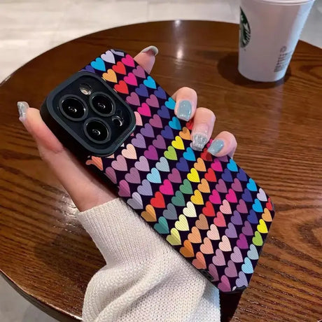 A woman holding a phone case with hearts on it