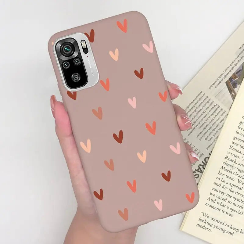 a woman holding a phone case with hearts on it