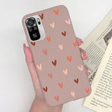 a woman holding a phone case with hearts on it