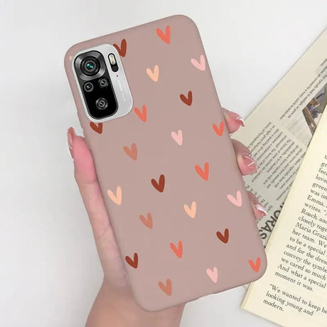 a woman holding a phone case with hearts on it