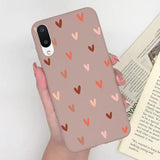 a woman holding a phone case with hearts on it
