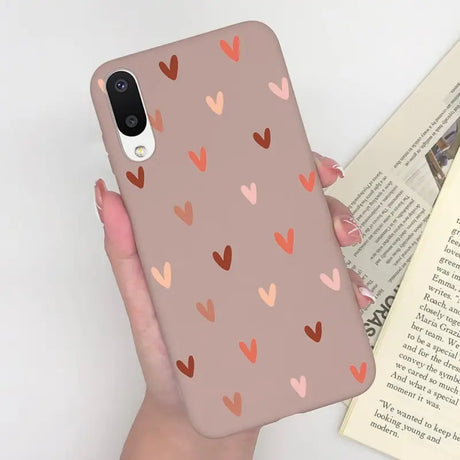 a woman holding a phone case with hearts on it