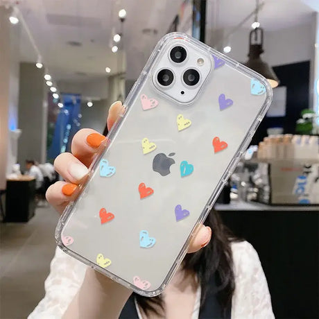 A woman holding up a phone case with hearts on it