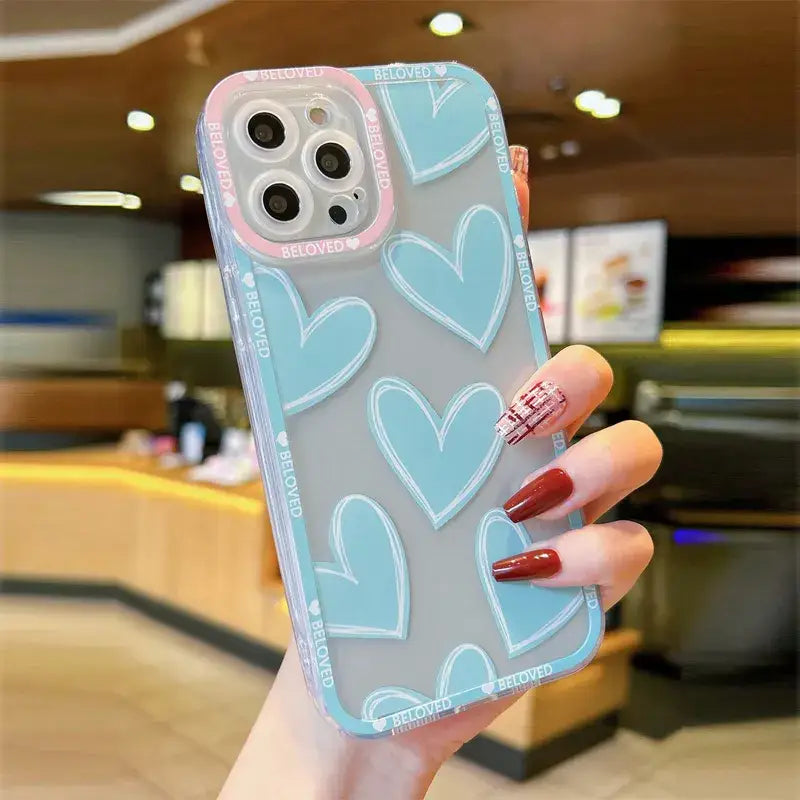 a woman holding a phone case with hearts on it