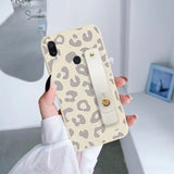 a woman holding a phone case with a phone holder