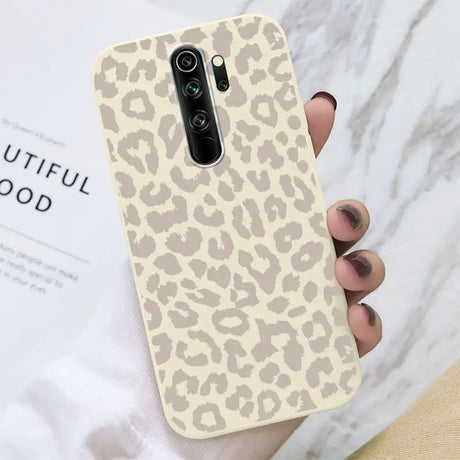 A woman holding a phone case with a leopard print