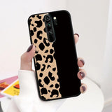 A woman holding a phone case with a leopard print