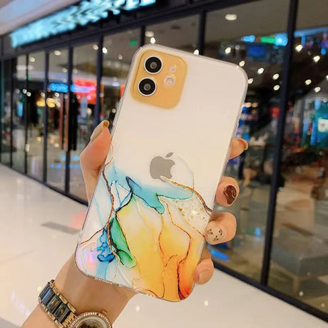 A woman holding up a phone case with a marble pattern