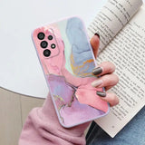 a woman holding a phone case with a marble pattern