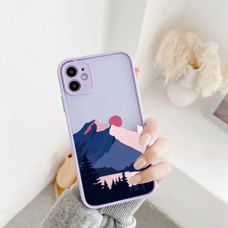 A woman holding a phone case with a mountain scene