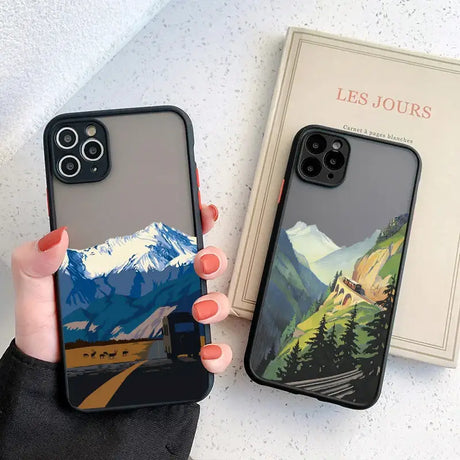 A woman holding a phone case with a mountain scene