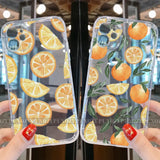 a woman holding up a phone case with oranges on it