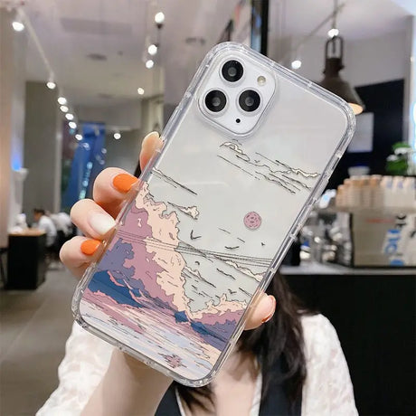 A woman holding up a phone case with a painting on it