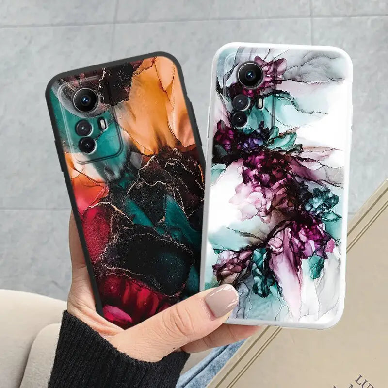 a woman holding a phone case with a painting on it