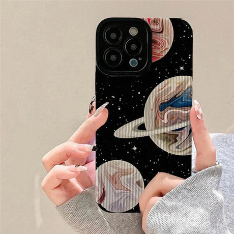 A woman holding a phone case with a painting on it