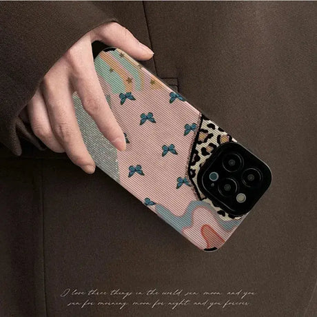 A woman holding a phone case with a pattern on it