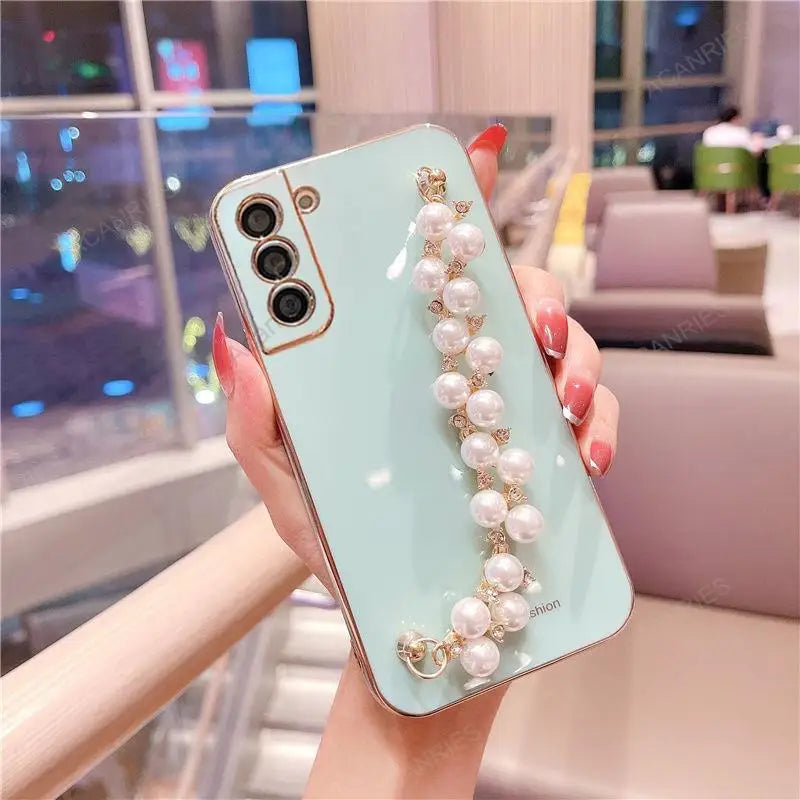 a woman holding a phone case with pearls and pearls