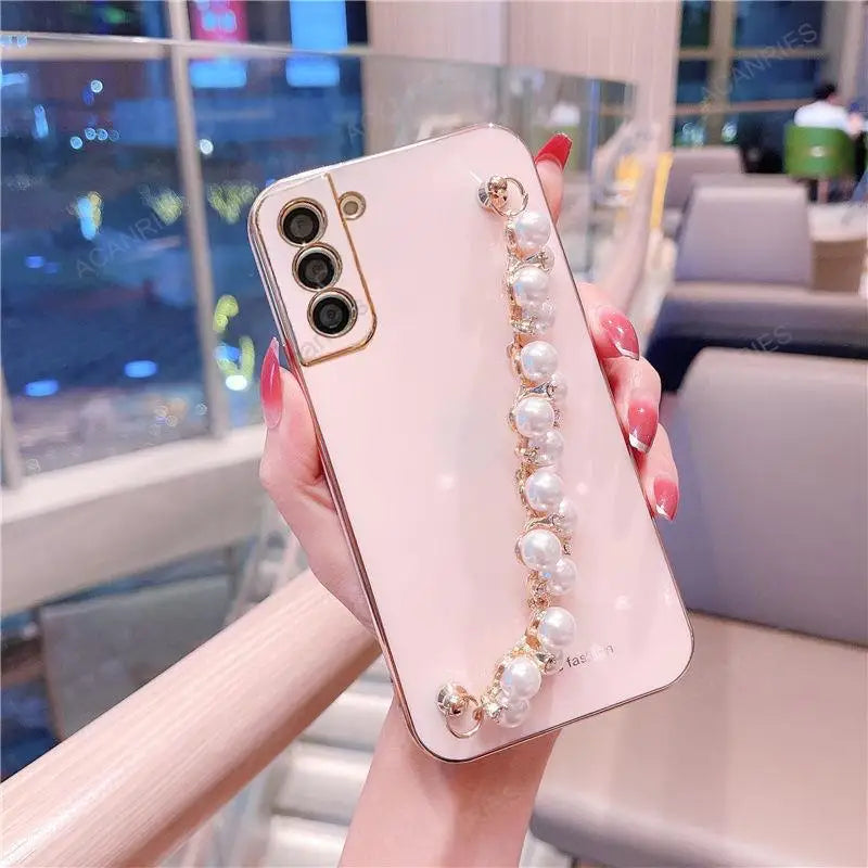 a woman holding a phone case with pearls and pearls