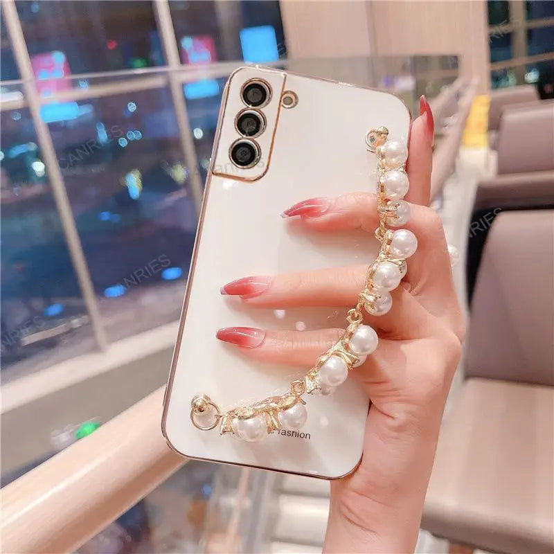 a woman holding a phone case with pearls and pearls