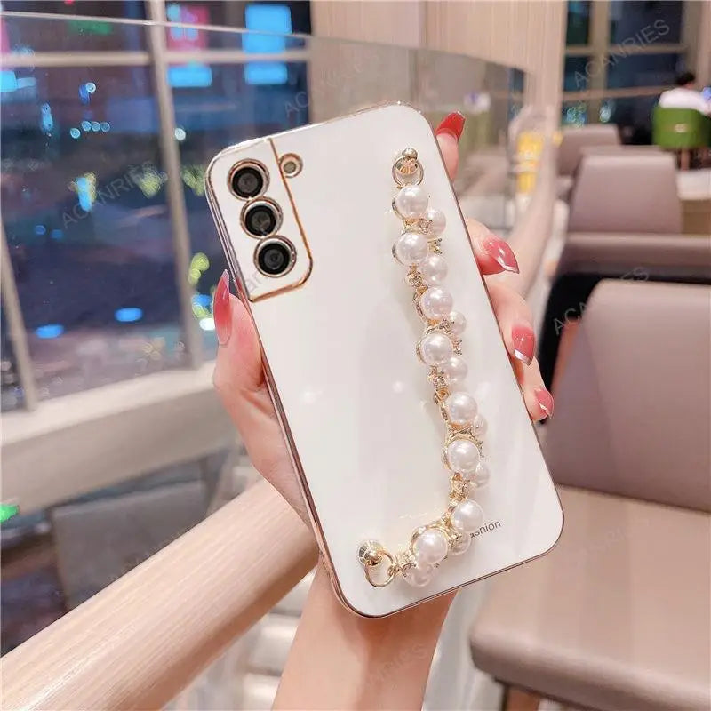 a woman holding a phone case with pearls and pearls