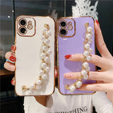 a woman holding a phone case with pearls and pearls