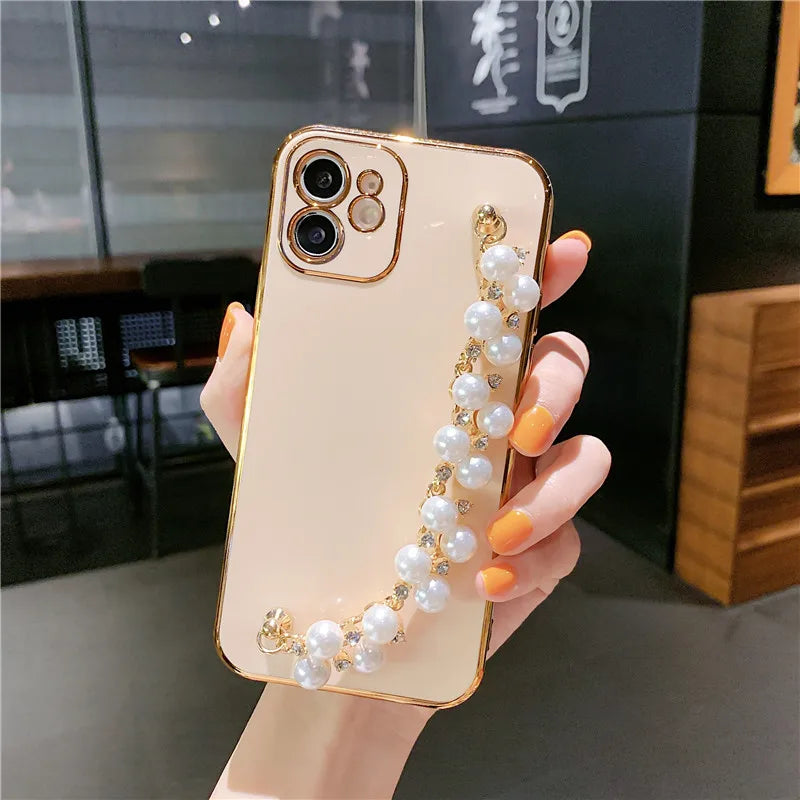 a woman holding a phone case with pearls and pearls