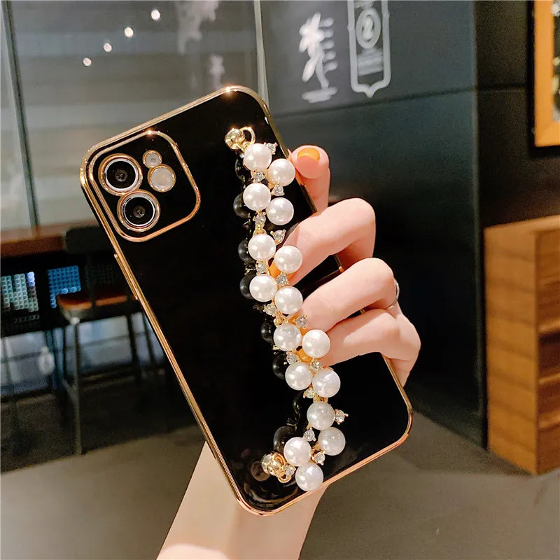 a woman holding a phone case with pearls and pearls