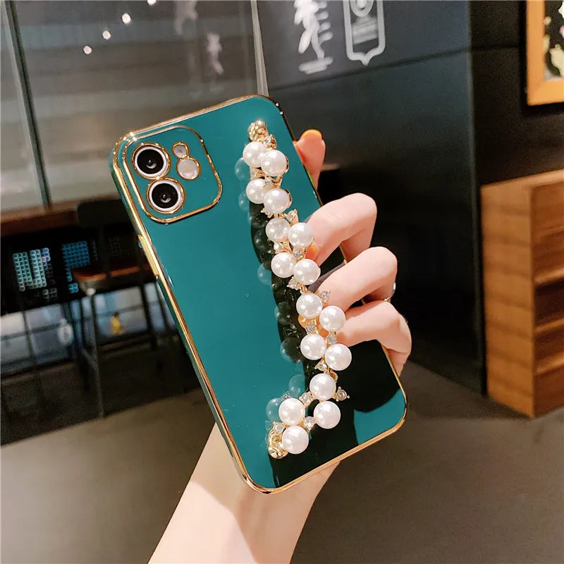 a woman holding a phone case with pearls and pearls