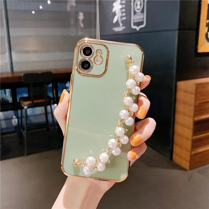 a woman holding a phone case with pearls and pearls