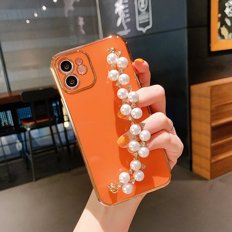 a woman holding a phone case with pearls