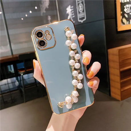 a woman holding a phone case with pearls and pearls