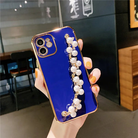 a woman holding a phone case with pearls and pearls