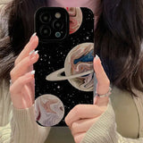 a woman holding up her phone case with a picture of the planets
