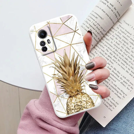 A woman holding a phone case with a pine on it