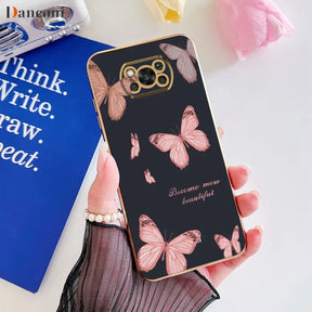 a woman holding a phone case with pink butterflies on it
