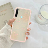 a woman holding a phone case with a pink and white pattern