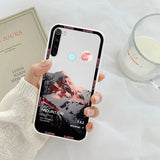a woman holding a phone case with a pink sunset on it