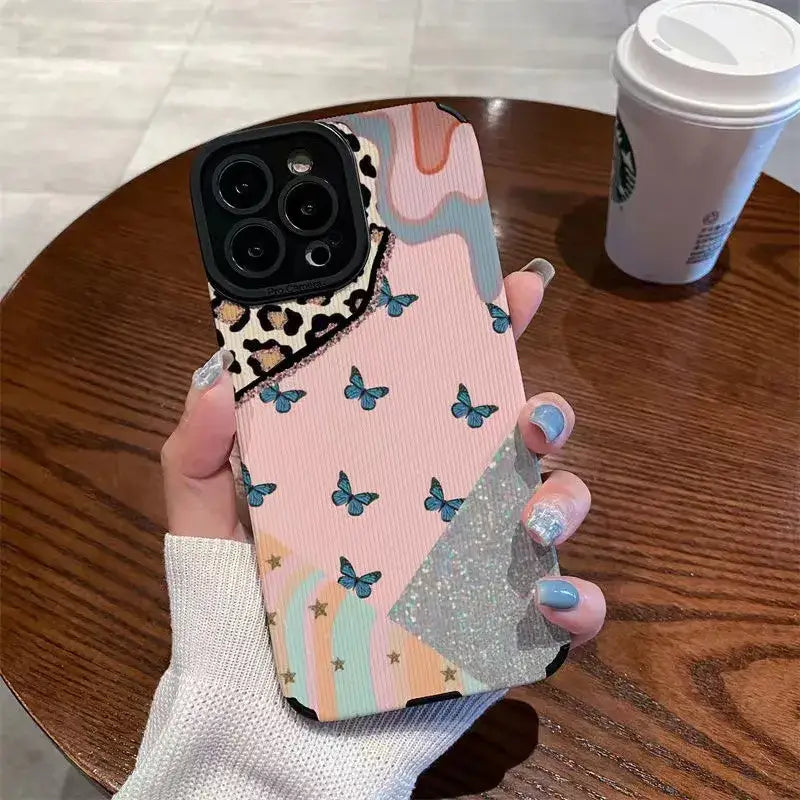 a woman holding a phone case with a pink and blue butterfly pattern