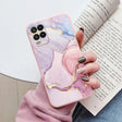 a woman holding a phone case with a pink marble pattern