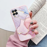 a woman holding a phone case with a pink marble pattern