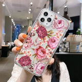 A woman holding up a phone case with pink flowers on it