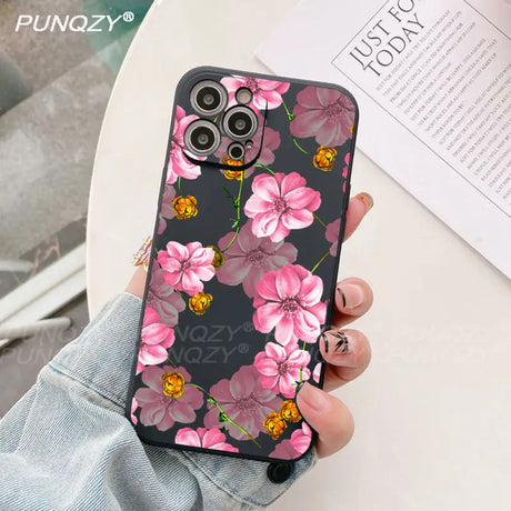 A woman holding a phone case with pink flowers on it