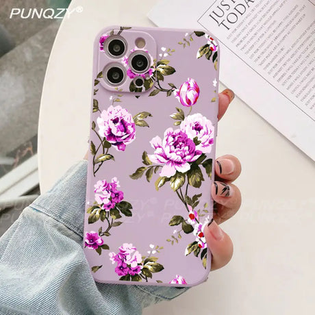 A woman holding a phone case with pink flowers on it