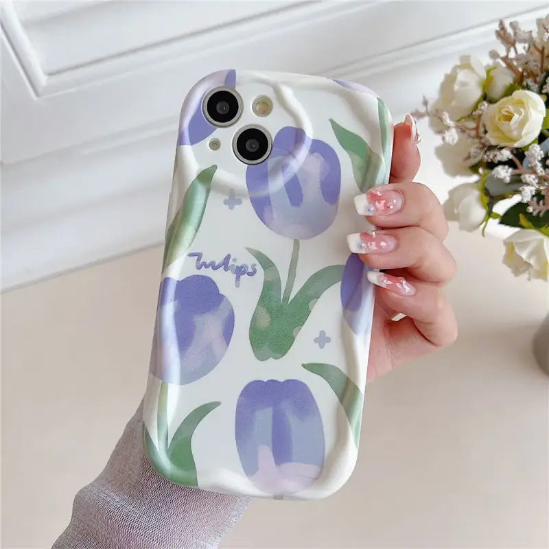 A woman holding a phone case with purple flowers on it