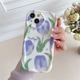 a woman holding a phone case with purple flowers on it