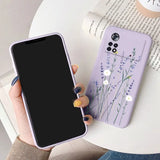 a woman holding a phone case with a purple flower design