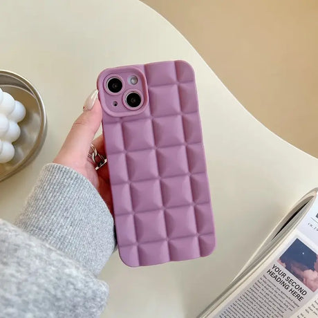 A woman holding a phone case with a purple quilt pattern