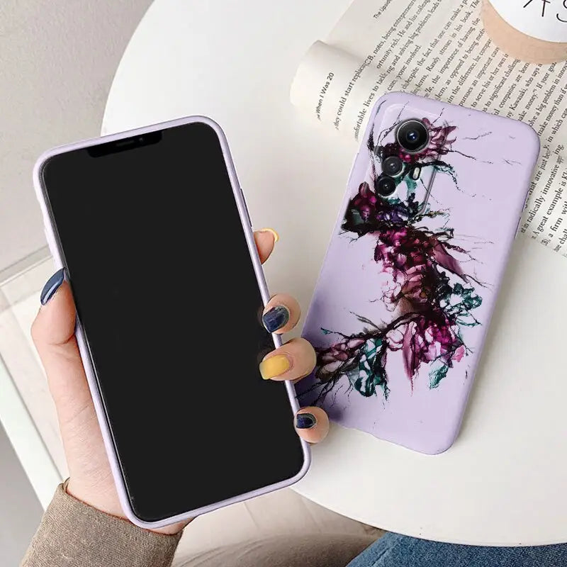 A woman holding a phone case with a purple flower on it