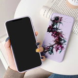 a woman holding a phone case with a purple flower on it