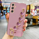a woman holding a phone case with purple stones